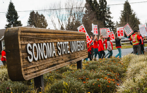 Faculty on strike at E.Cotati Ave main SSU entrance with Sonoma State University sign in foreground.