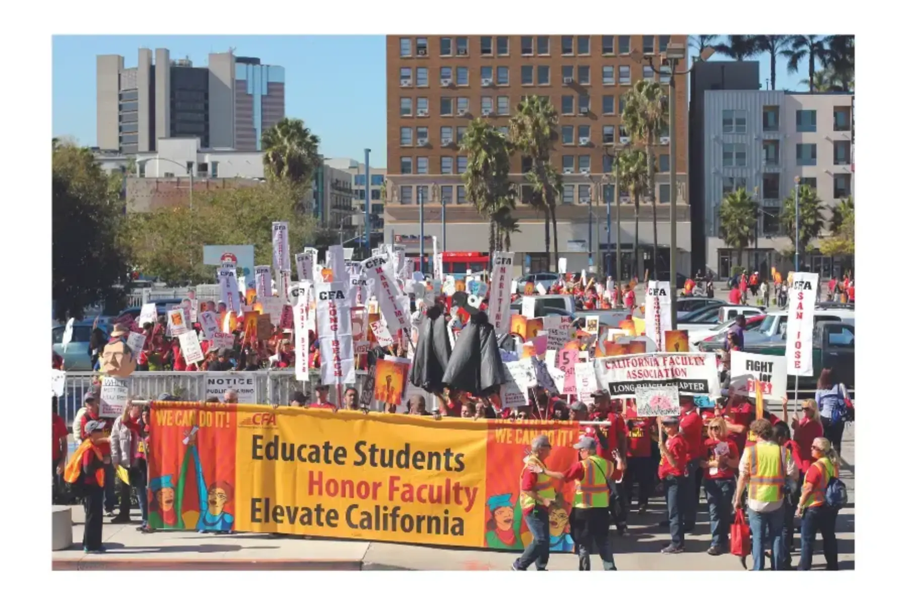 Photo of hundreds of people rallying outside office buildings. Hundreds of white signs saying California Faculty Association. Orange and yellow banner in the front reads Education students, honor faculty, elevate California.