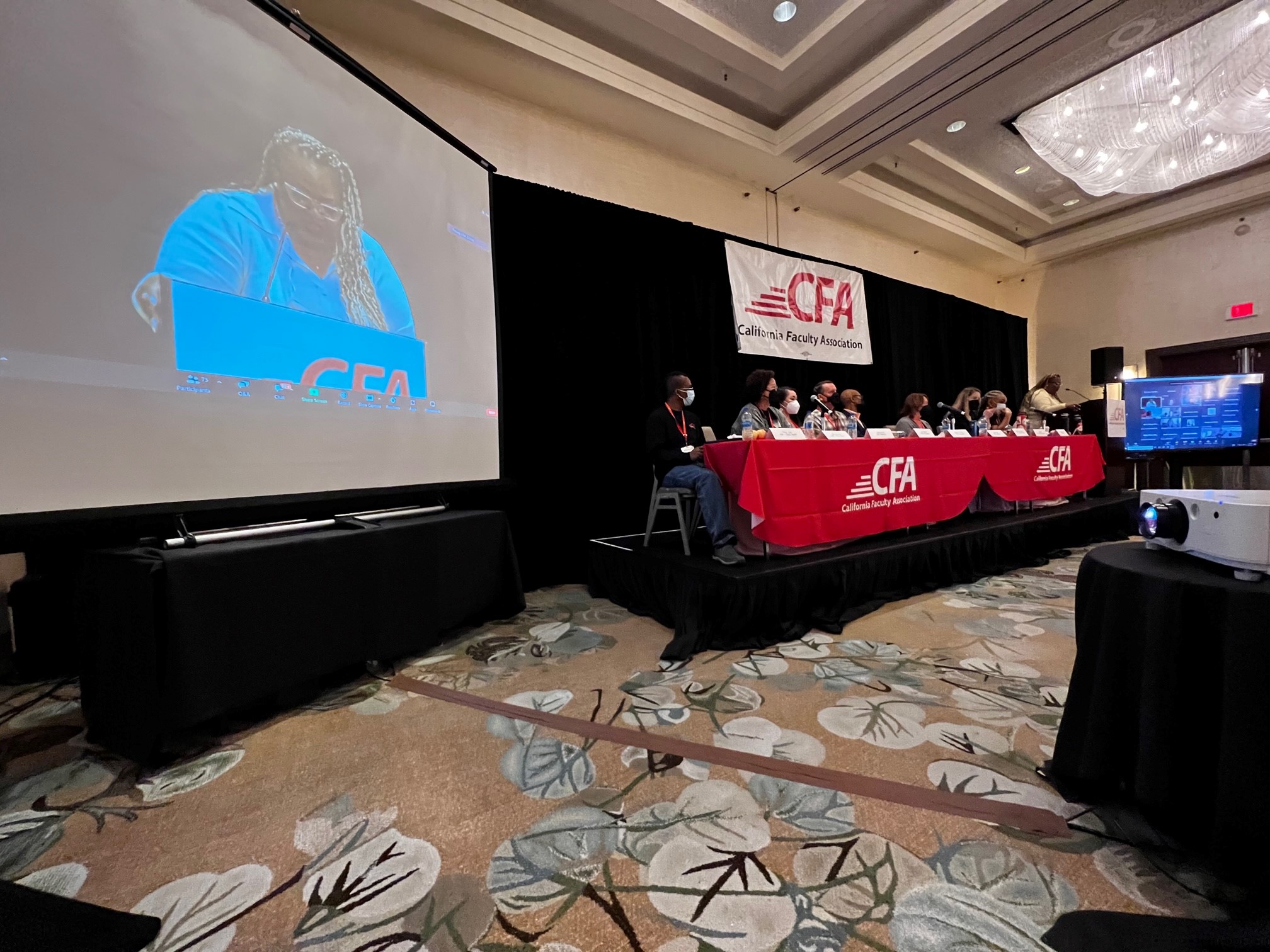 CFA Members sit at a desk watching a presentation