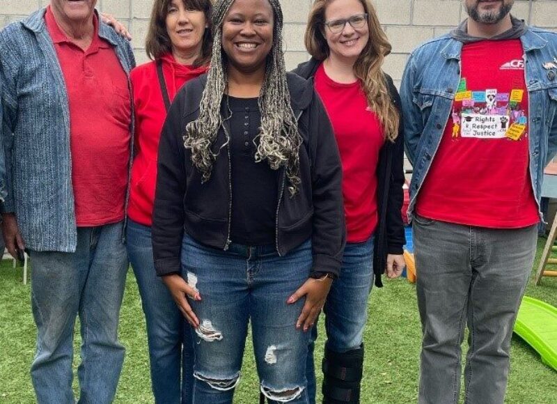 A group of members take photo outdoors in CFA red shirts