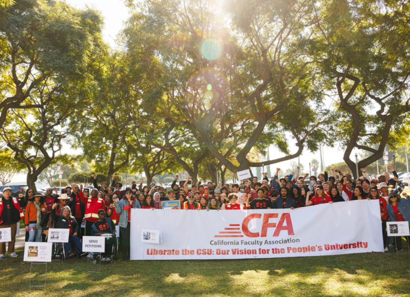 A big group of people outdoors with banners and signs.