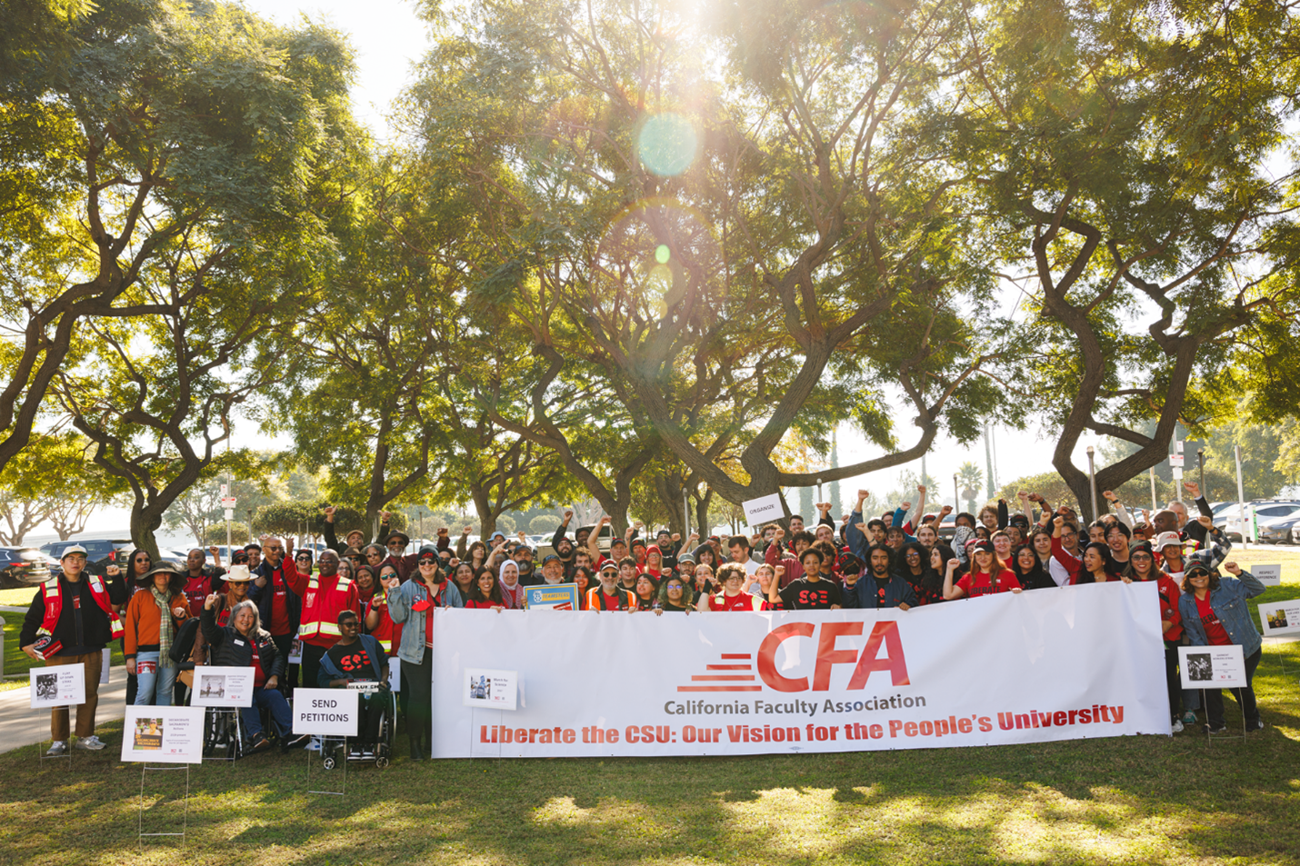 A big group of people outdoors with banners and signs.