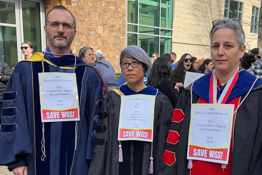 Three members in their regalia with signs on their chests about how the layoffs after serving the CSU for over 10 years.